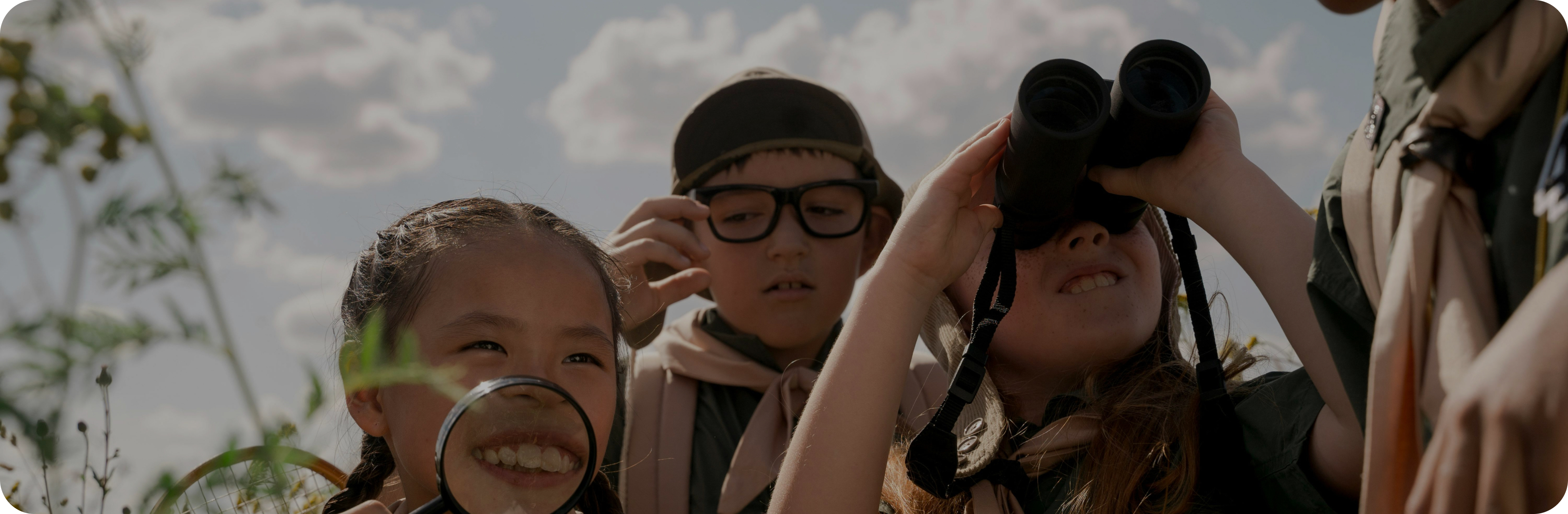 Young learners exploring the world with binoculars and a magnifying glass