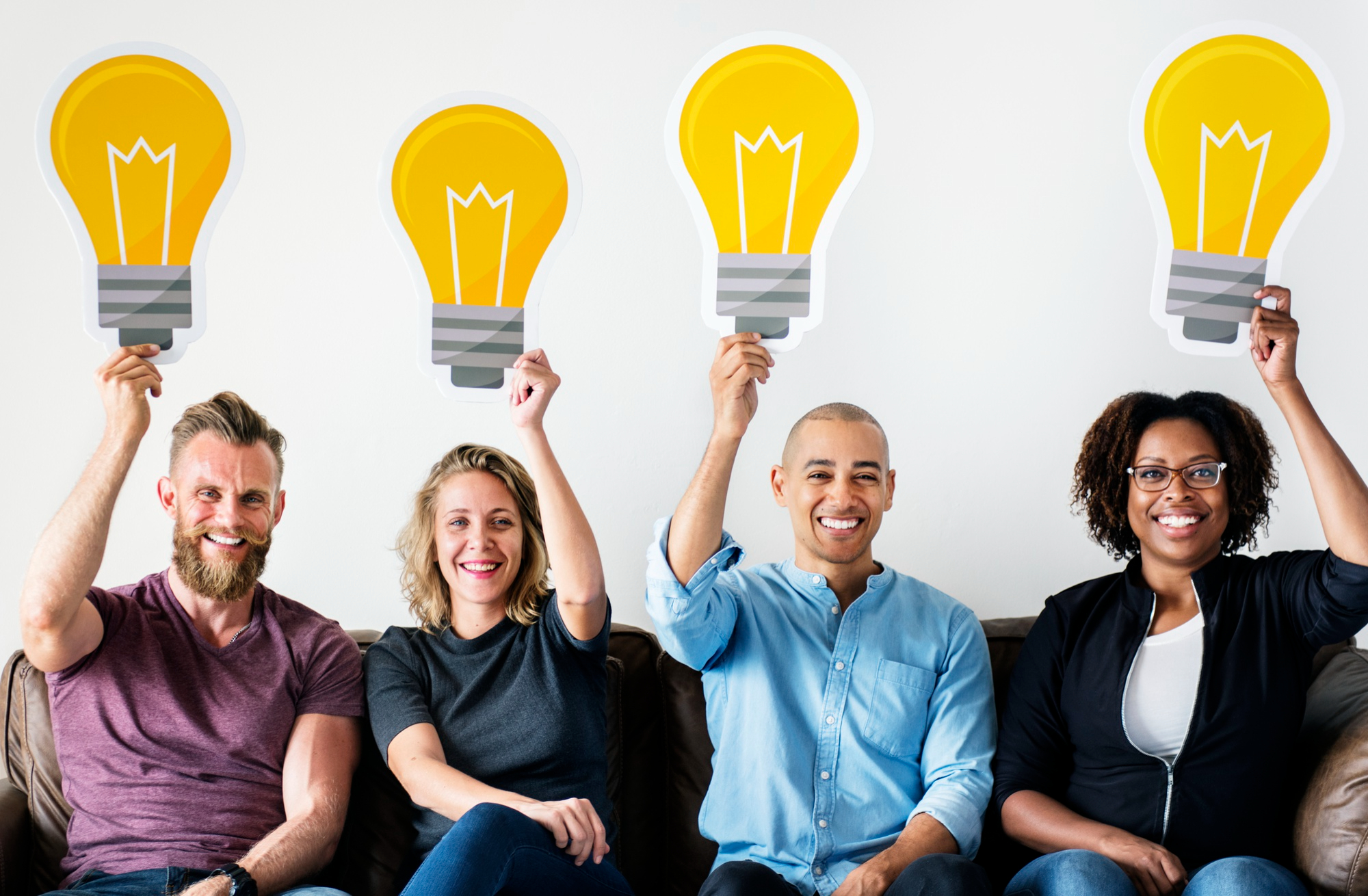 Educators holding up lightbulb cut-outs, sharing ideas together